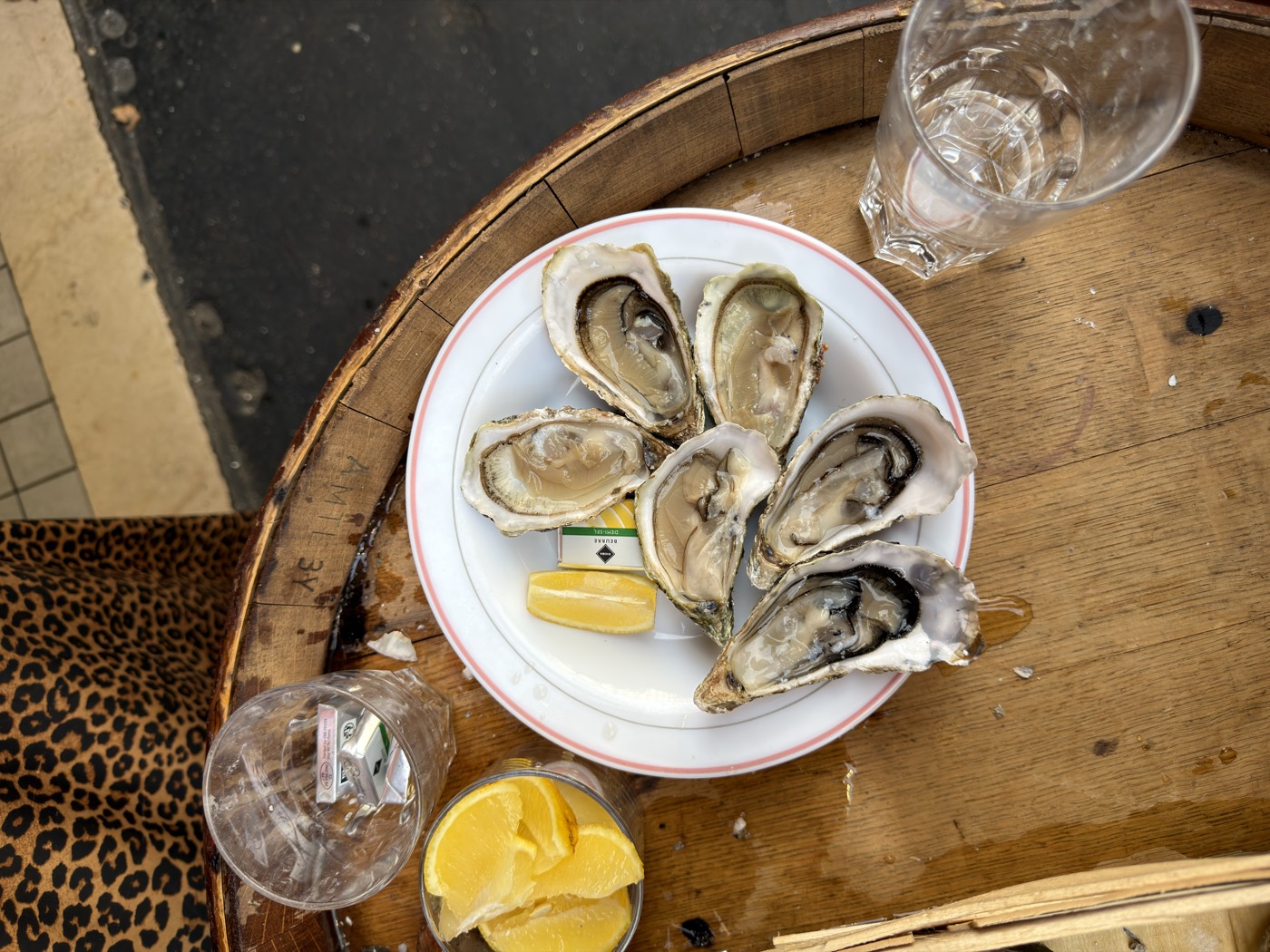 Assiette d'huîtres fraîches avec citron posée sur un tonneau
