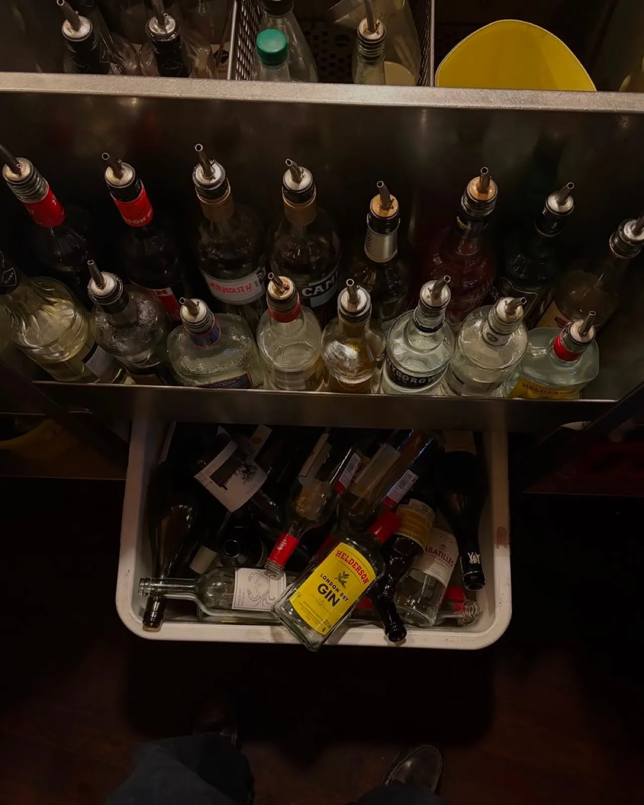 Bouteilles et becs verseurs derrière le bar des Parigots