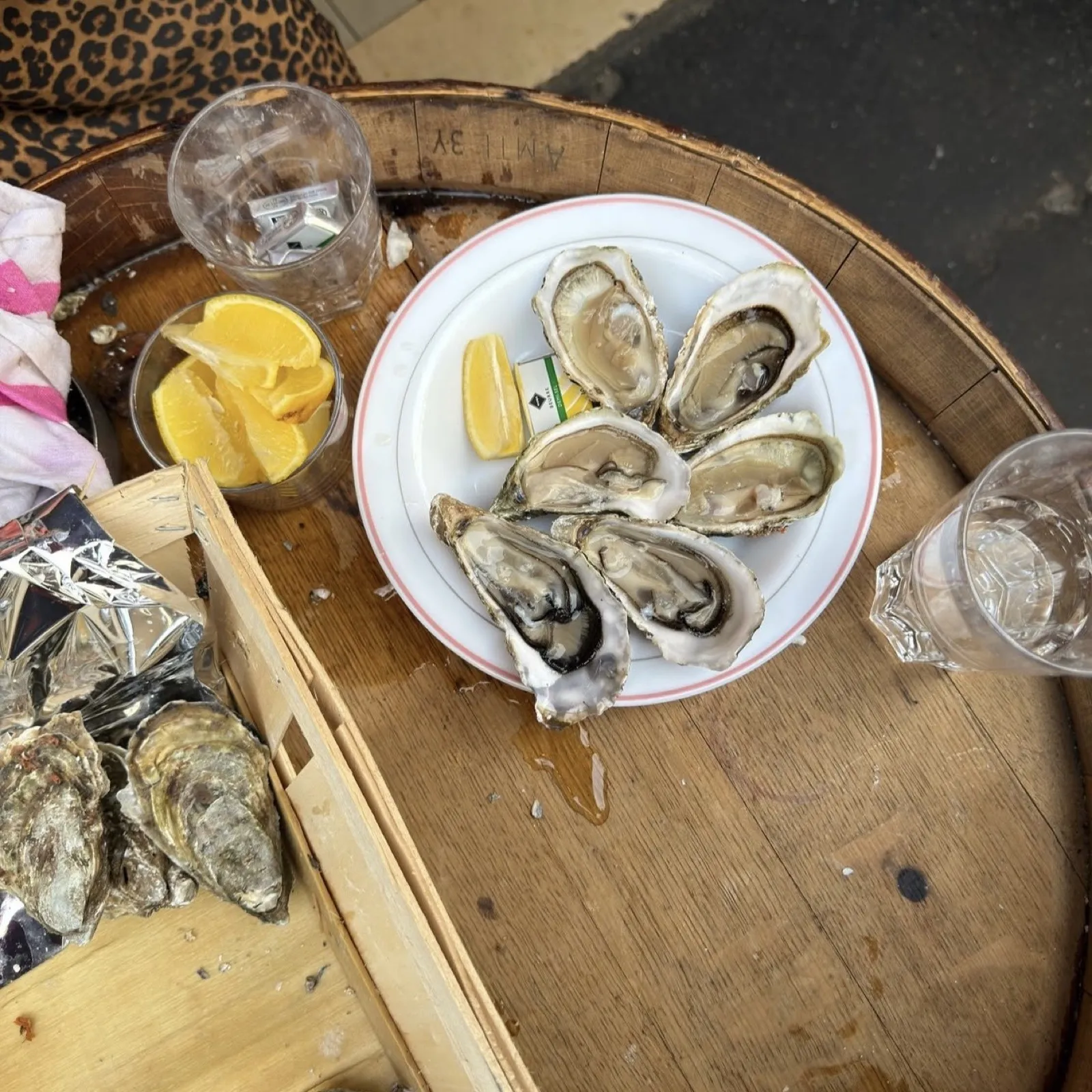 Assiette d'huîtres et citron posée sur un tonneau en terrasse