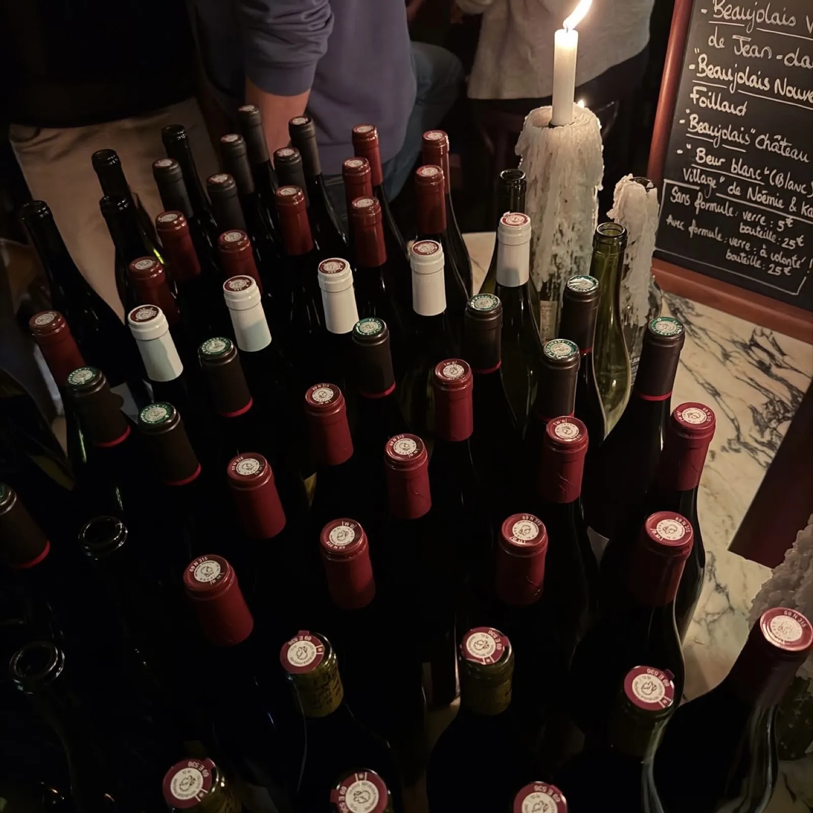 Bouteilles de vin alignées devant l'ardoise beaujolais