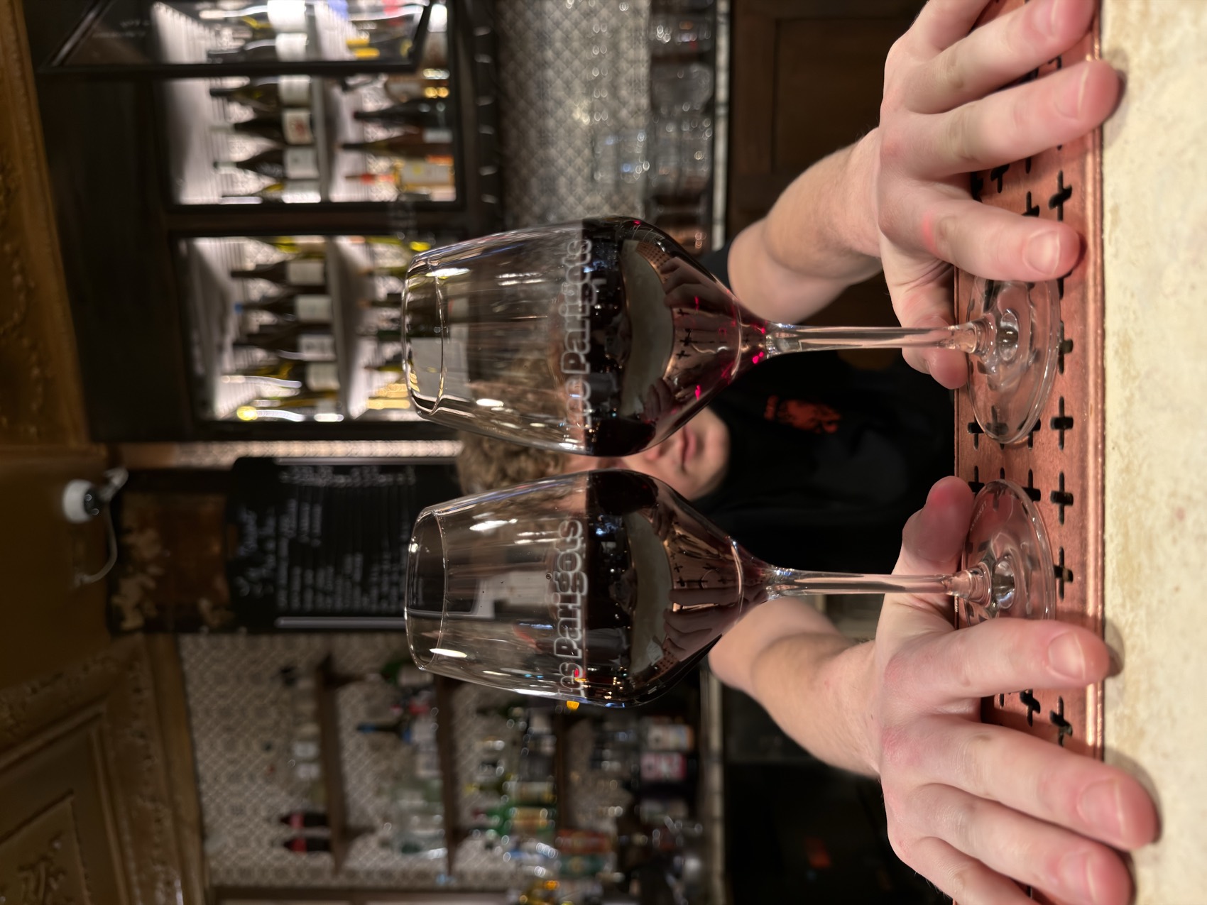 Deux verres de vin rouge que l'on trinque en gros plan